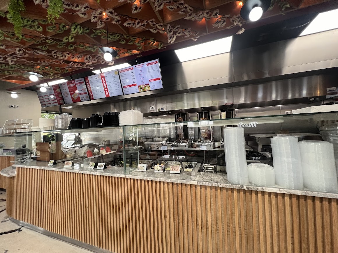 Order counter at Baba Saj restaurant, showcasing the menu, open kitchen, and food options.